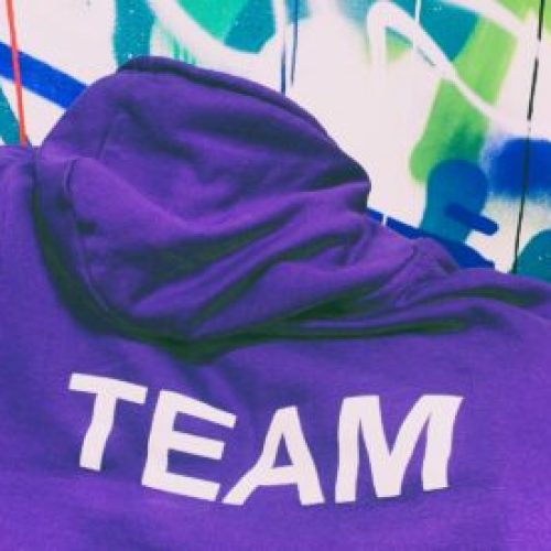 A purple hoodie with the word Team written on it in white letters